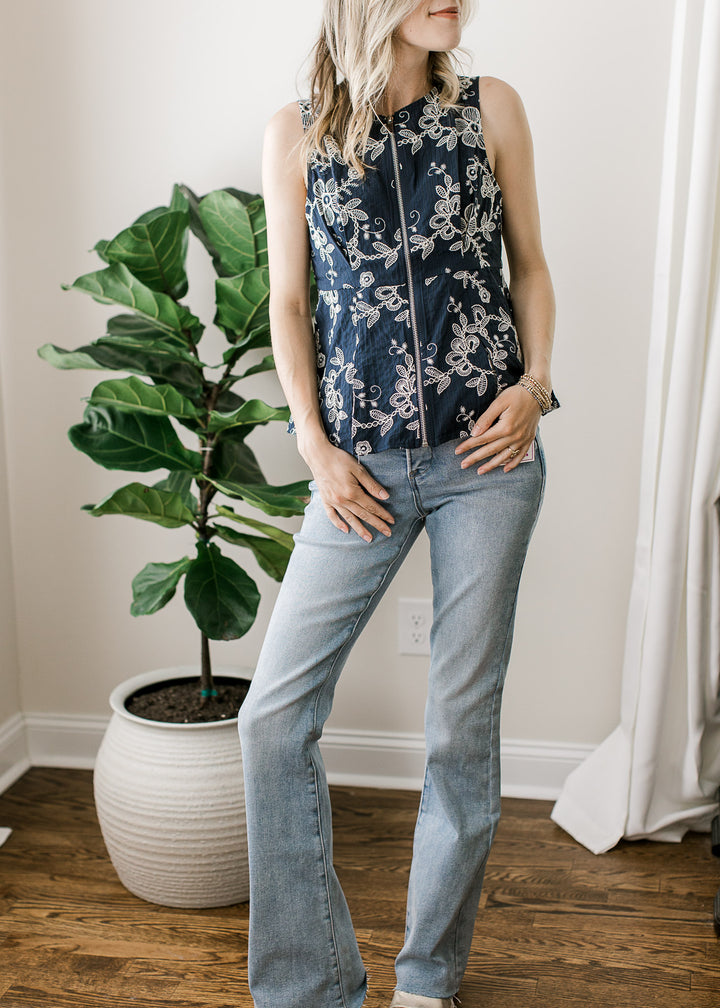 Model wearing medium/light wash jeans with  high rise bootcut fit and a raw hemline. 
