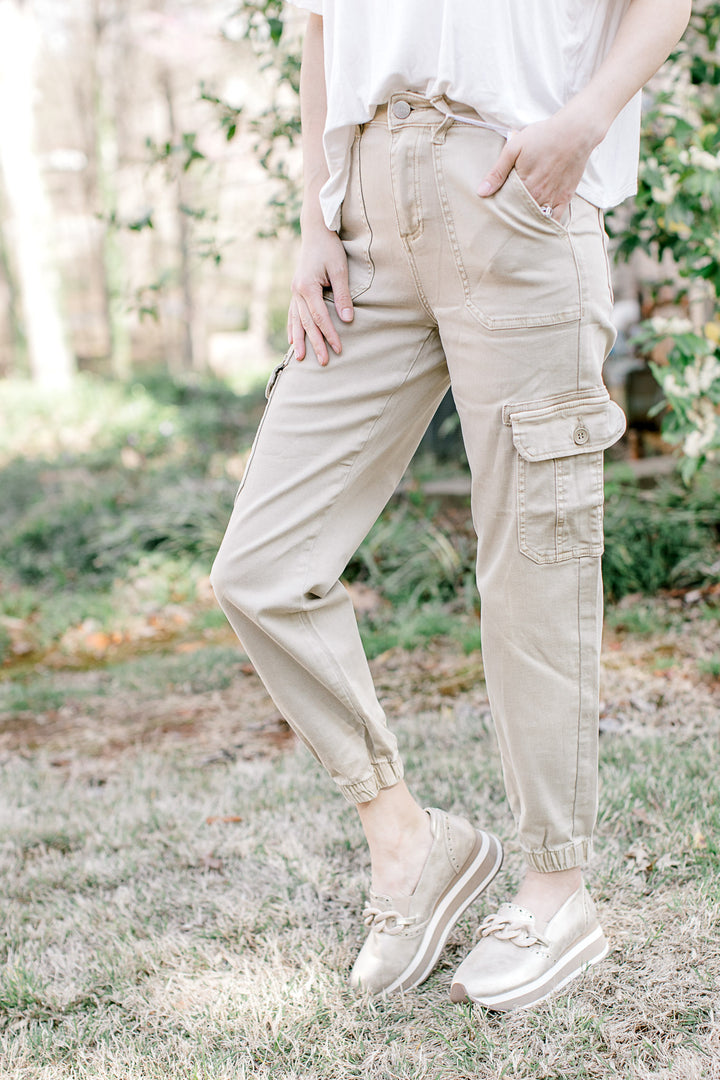 Model wearing Risen brand cargo joggers with a soft taupe color, comprised of cotton and spandex.