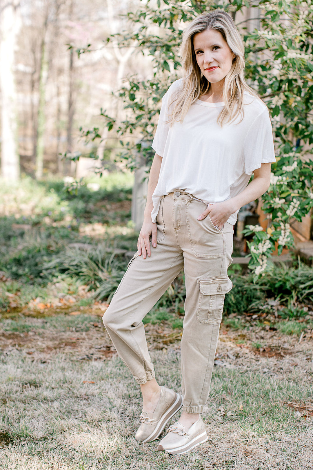 Model wearing a tee, loafers and soft taupe joggers with a cargo pockets. 