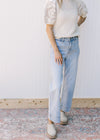 Model wearing light wash jeans with wide legs and a high waist. 