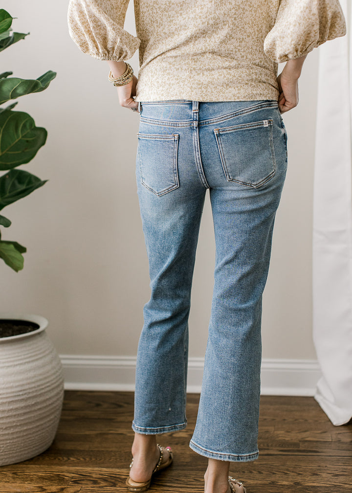 Back view of Model wearing medium wash jeans with a mid rise, cropped kick flare fit.