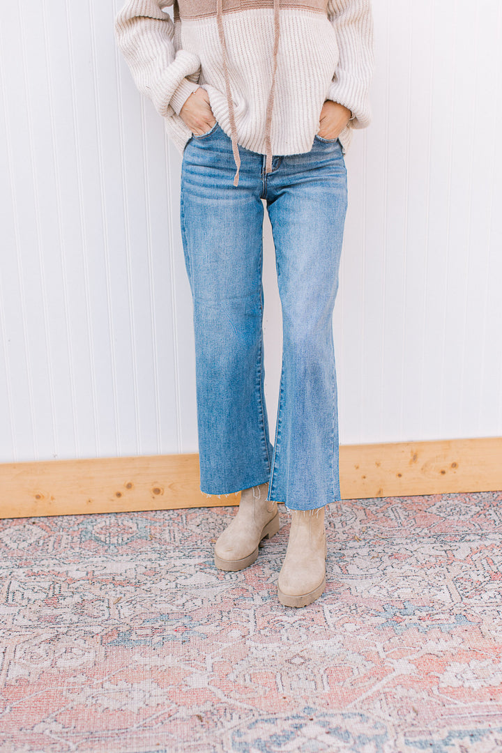Model wearing booties with medium wash jeans with soft waistband, wide leg and mid rise fit. 