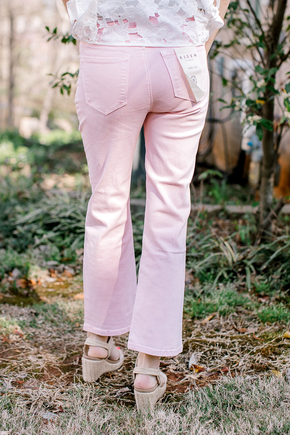 Back view of Model wearing cropped pale pink denim with tummy control and a straight leg fit. 
