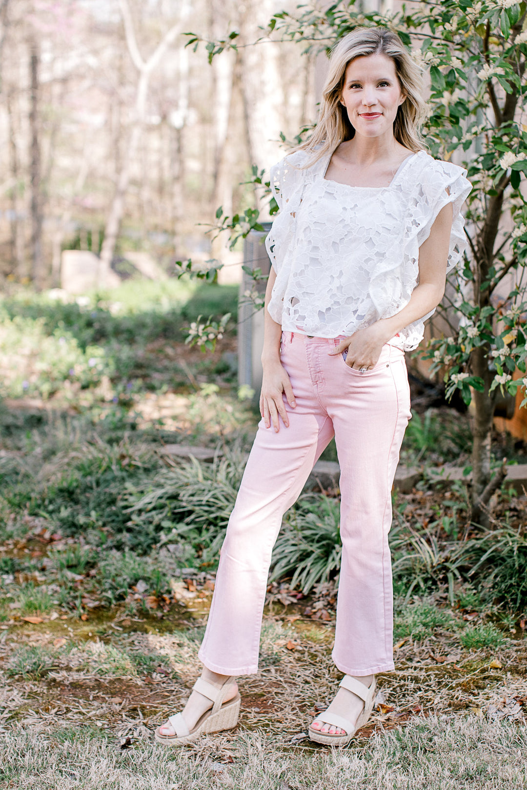 Model wearing a white top, sandals and cropped pink denim with a straight leg fit. 