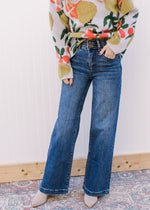 Model wearing Medium wash, wide leg jeans with two button closure and elastic in waist.