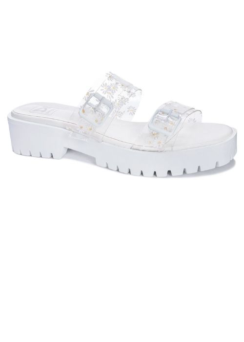 White platform slides with a daisy design on a clear strap and oversized buckles. 
