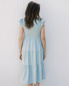 Back view of Model wearing a light blue midi with a smocked bodice and flutter capped sleeves. 