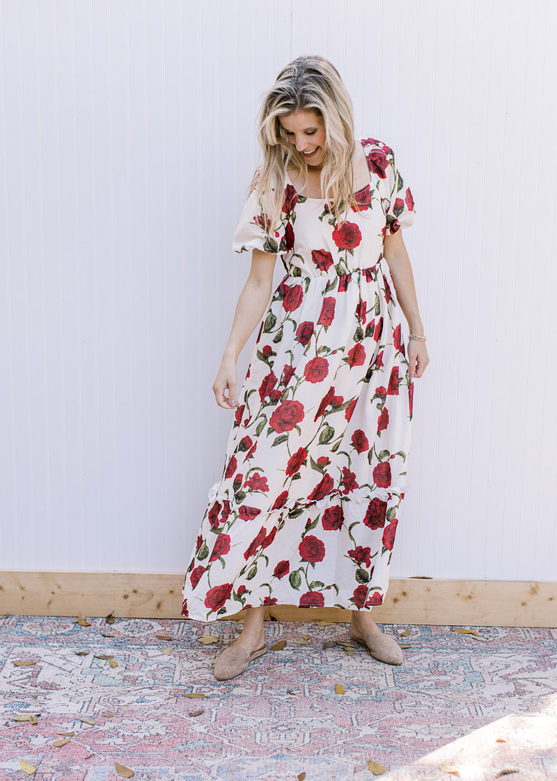 Model wearing mules with a cream maxi with red roses, square neck and bubble short sleeves. 