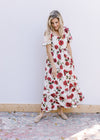 Model wearing a cream dress with red roses, square neck and bubble short sleeves. 