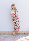 Model wearing a cream lightweight dress with red roses, square neck and bubble short sleeves. 