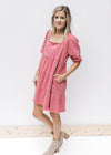 Model wearing booties with a rose above the knee dress with a babydoll fit and bubble short sleeves.