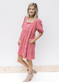 Model wearing booties with a rose above the knee dress with a babydoll fit and bubble short sleeves.