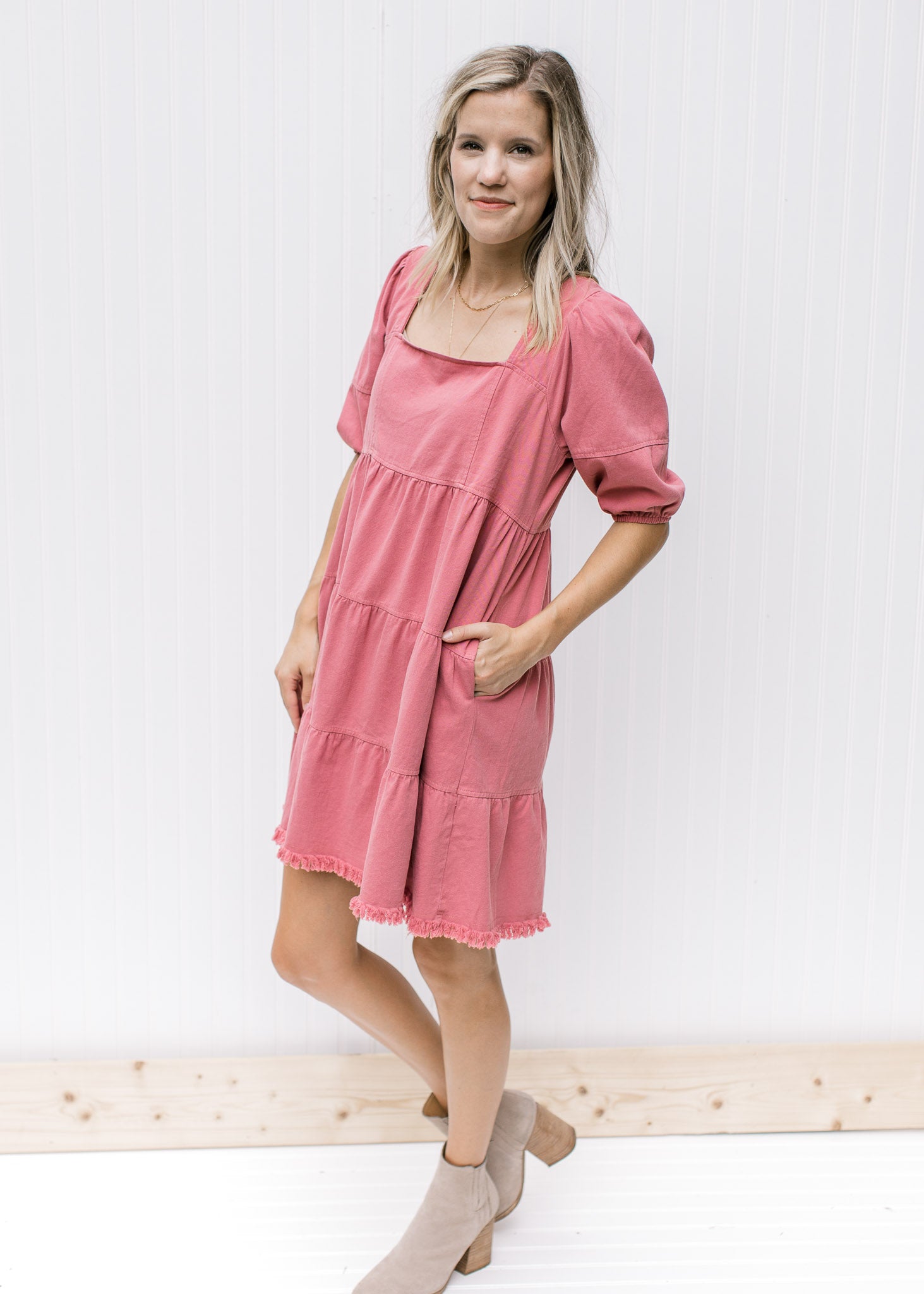 Model wearing booties with a rose above the knee dress with a babydoll fit and bubble short sleeves.