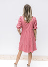 Back view of a rose colored dress with a frayed hem, bubble short sleeves and a babydoll fit.