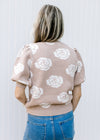 Back view of Model wearing a soft pink sweater with cream roses and bubble short sleeves.