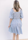 Back view of smocking on a white dress with ditsy blue floral design and bubble short sleeves.