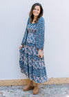 Model wearing a navy dress with cream flowers, a smocked bodice and bubble long sleeves. 