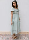 Model wearing sandals with a soft sage midi with a embroidered bodice and short sleeves.
