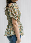 Side view of bubble short sleeve and smocked bodice on a sage top with orange, pink and blue floral.