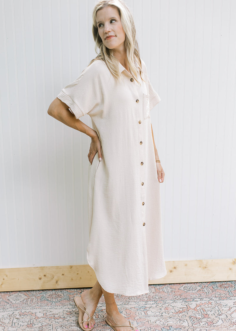 Model wearing an oatmeal dress with button front, collar and short sleeves.