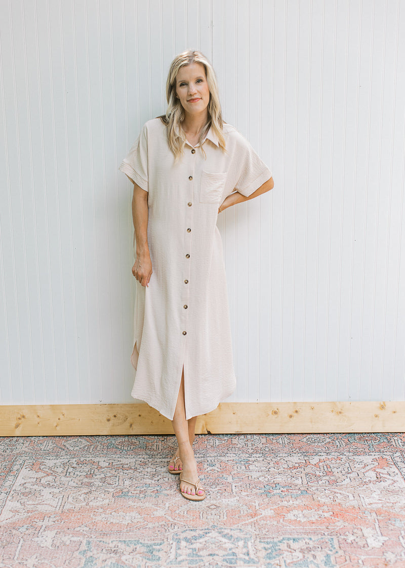 Model wearing sandals with an oatmeal dress with button front, collar and short sleeves.