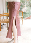 Model wearing a chestnut maxi with subtle floral pattern, a satin material and a single side split.