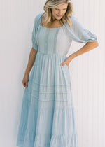 Model wearing a seafoam colored maxi dress with bubble short sleeves and lace detail on the bodice. 