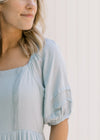 Close up view of bubble short sleeves and lace detail on the bodice of a seafoam maxi dress. 