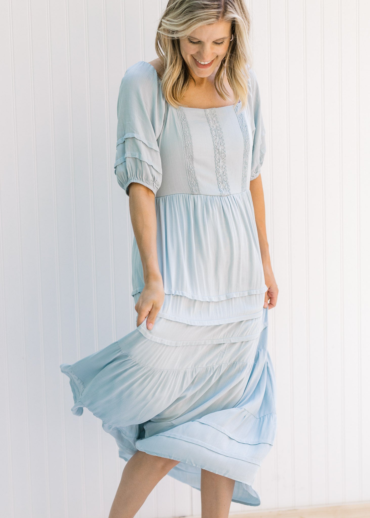 Model turning in a seafoam colored maxi dress with short sleeves and lace detail on the bodice. 