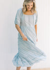 Model twisting in a seafoam colored maxi dress with short sleeves and lace detail on the bodice. 