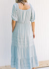 Back view of Model wearing a seafoam colored maxi dress with lace detail on the bodice. 
