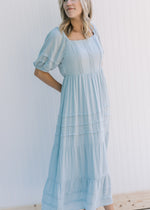 Model wearing a seafoam colored maxi dress with a round neck and bubble short sleeves. 