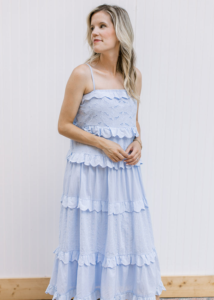 Model wearing a pale blue midi with floral eyelets, ruffle tiers, elastic band and spaghetti straps.