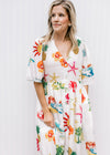 Close up of v-neck, and short sleeves on a cream midi with a multicolored tropical pattern. 