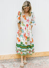 Model wearing a button up cream midi with av-neck and multicolored tropical pattern. 