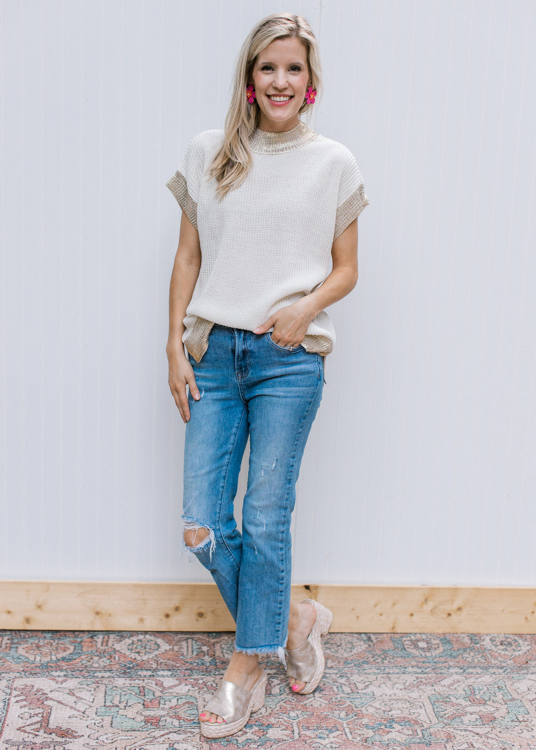 Model wearing jeans with a cream cable knit top with gold shimmer at neck, cuff and hem.