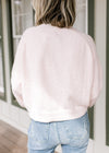 Back view of model wearing a pink cardigan with polyester material and long sleeves.