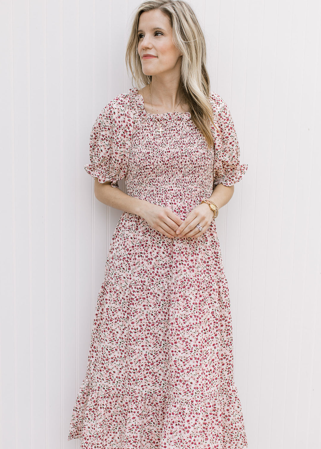Model wearing a cream dress with maroon floral, smocked bodice, square neck and short sleeves.