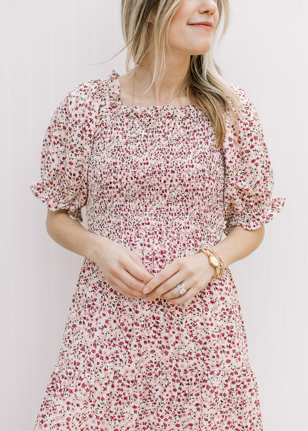 Model wearing a cream midi with maroon and pink floral, smocked bodice and short sleeves.