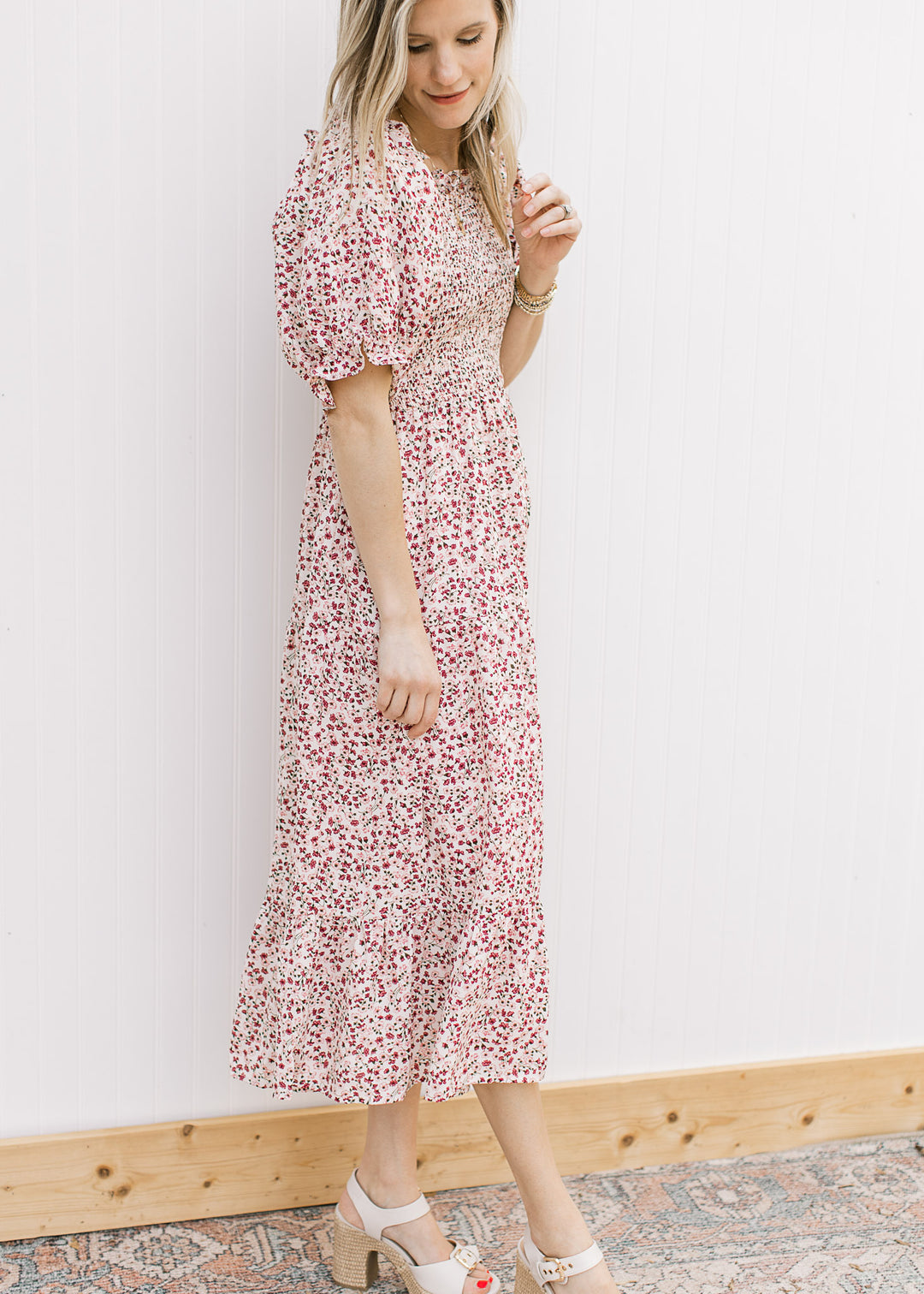 Model wearing heels and a cream midi with maroon and pink floral, smocked bodice and square neck.