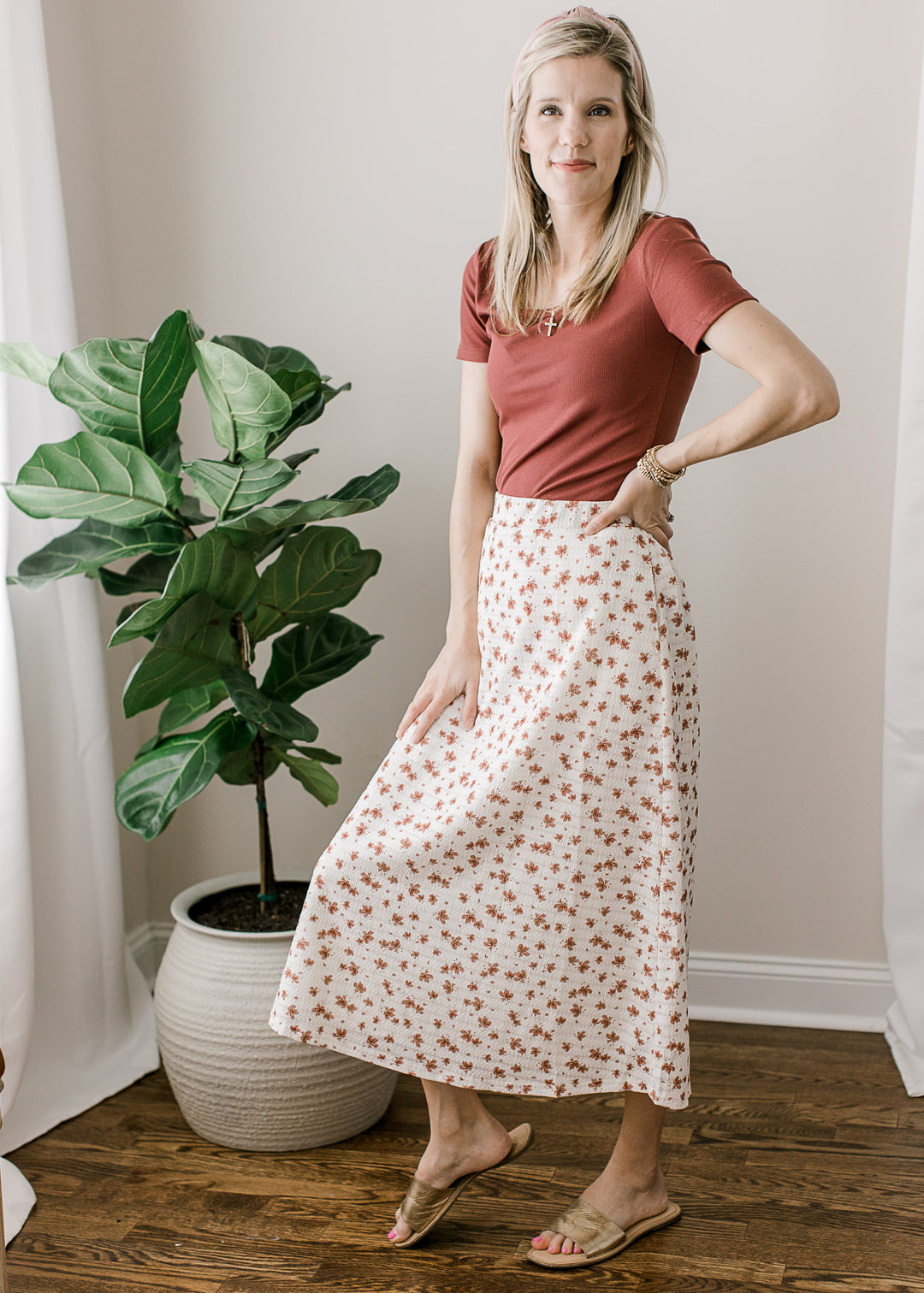 Model wearing sandals, skirt and a rose top with short sleeves, scoop neckline and a ribbed fabric.