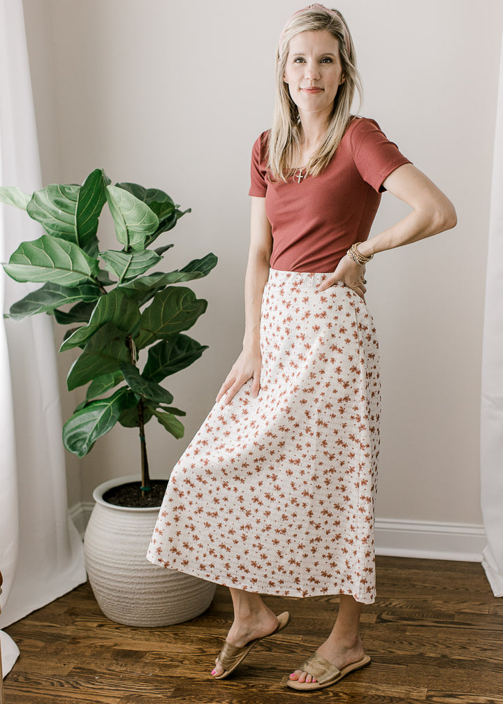 Model wearing sandals, skirt and a rose top with short sleeves, scoop neckline and a ribbed fabric.