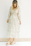 Model wearing wedges with a cream floral midi dress with elastic waistband and sheer long sleeves. 