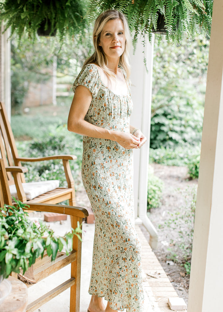  Model wearing a soft olive-green maxi with floral print, round neck and short sleeves. 