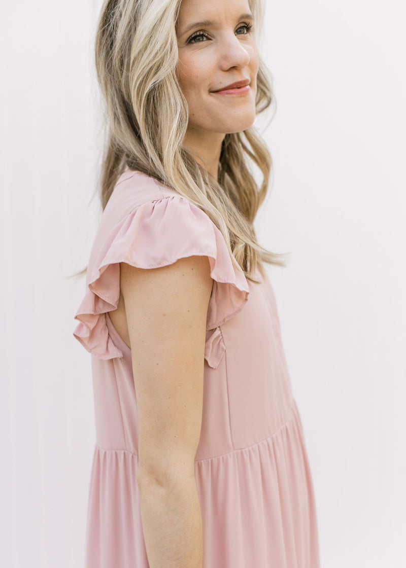 Close up of ruffle cap sleeve on a blush colored midi comprised of polyester. 