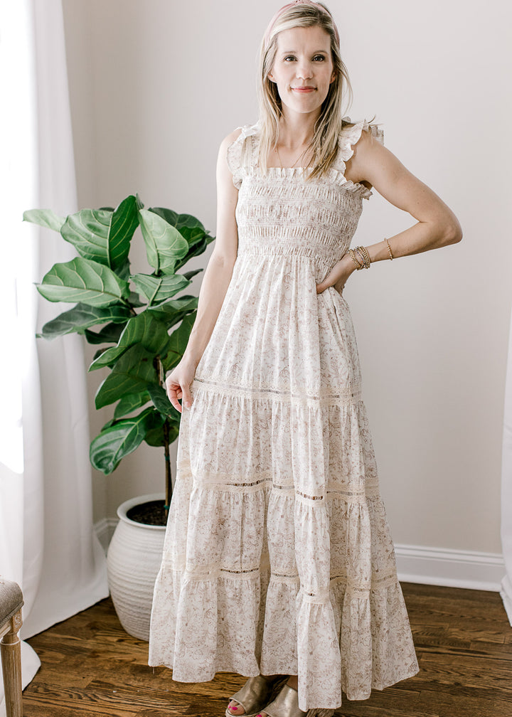 Model wearing sandals and a cream maxi with light brown bunny and floral and a smocked bodice.