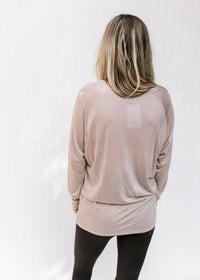 Back view of Model wearing a light purple long sleeve top with a round neck and a tencel material. 