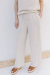 Close up of oatmeal colored linen pants with front patch pockets and wide legs. 
