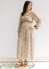 Model wearing a tan lined maxi with microfloral print, sheer long sleeves and a split front. 