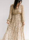 Model wearing a tan maxi dress with a microfloral print, sheer overlay and sheer long sleeves. 